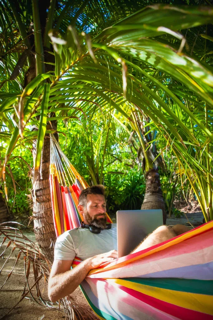 man working on laptop on exotic beach