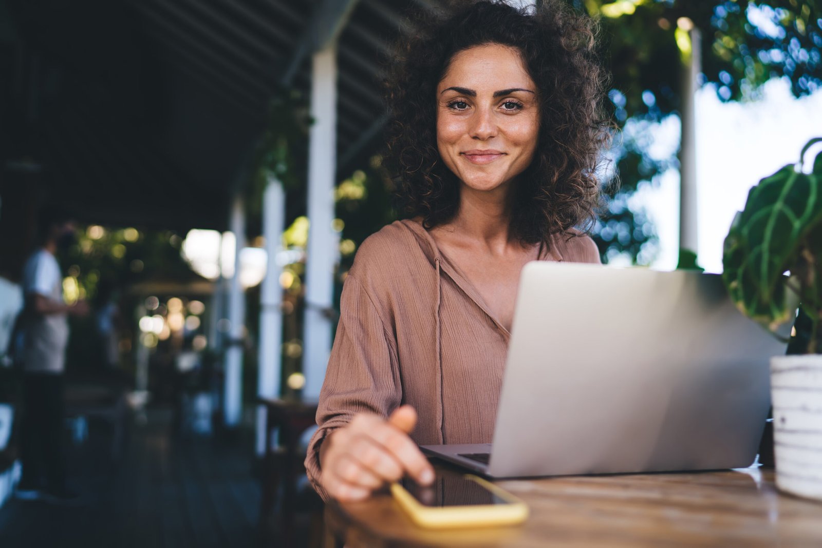 Portrait of happy Caucasian digital nomad smiling at camera during time for remote working, cheerful female blogger with modern laptop technology posing while doing freelance distance job
